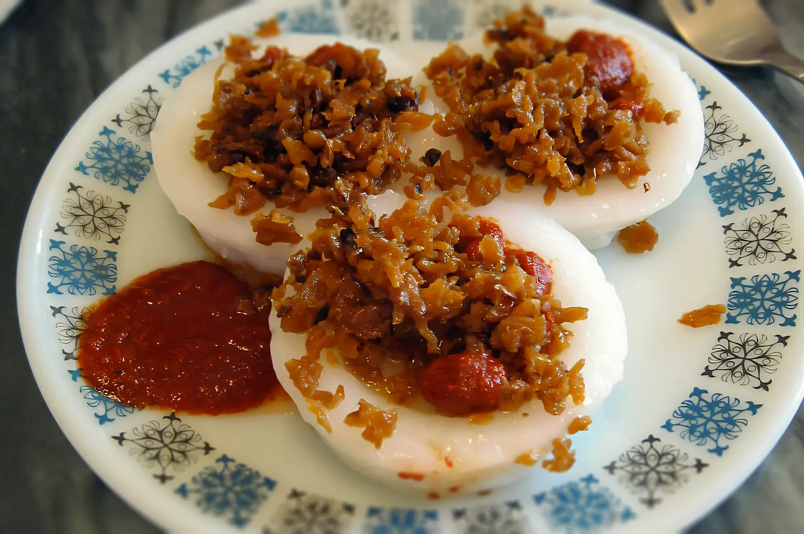 Top‑down close‑up of traditional Singapore chwee kueh rice cakes topped with preserved radish and chilli, a cheap kopitiam brunch option popular for budget breakfast in Singapore