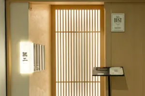 Front-facing wide shot of Sushi Muni Singapore entrance with shoji-style sliding doors, minimalist Japanese restaurant design and omakase dining ambiance