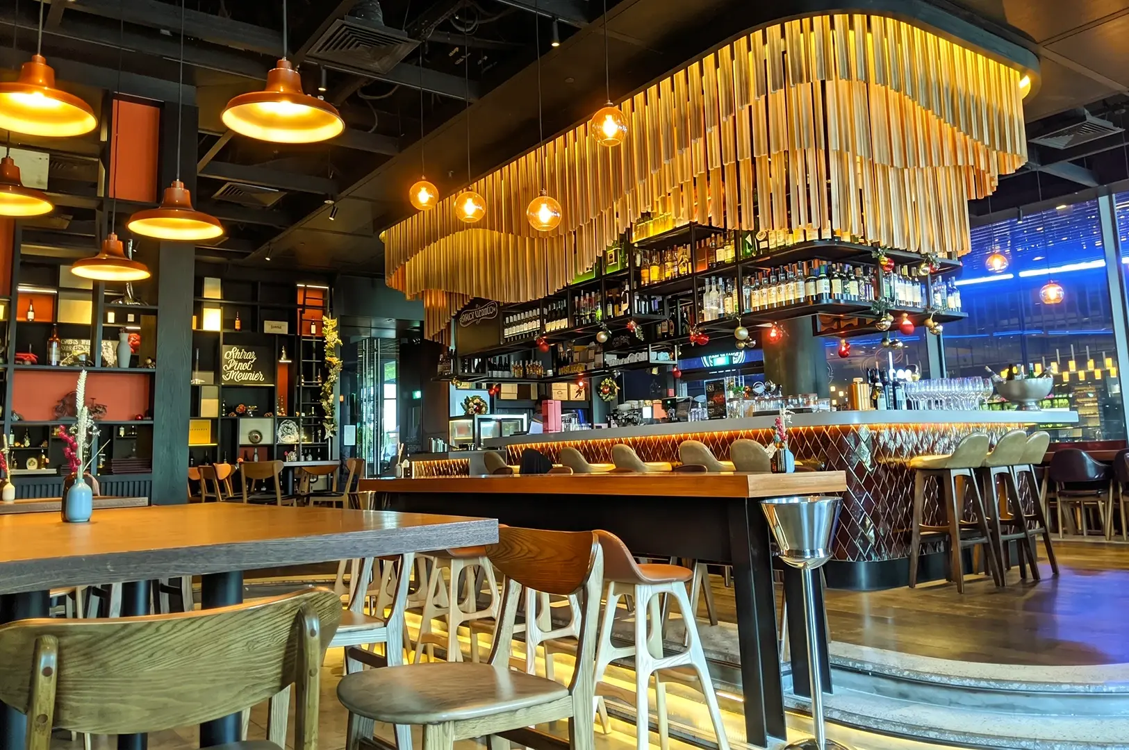 Wide-angle interior shot of The Spot Singapore showing stylish bar, warm lighting, and modern dining space inside Marina One