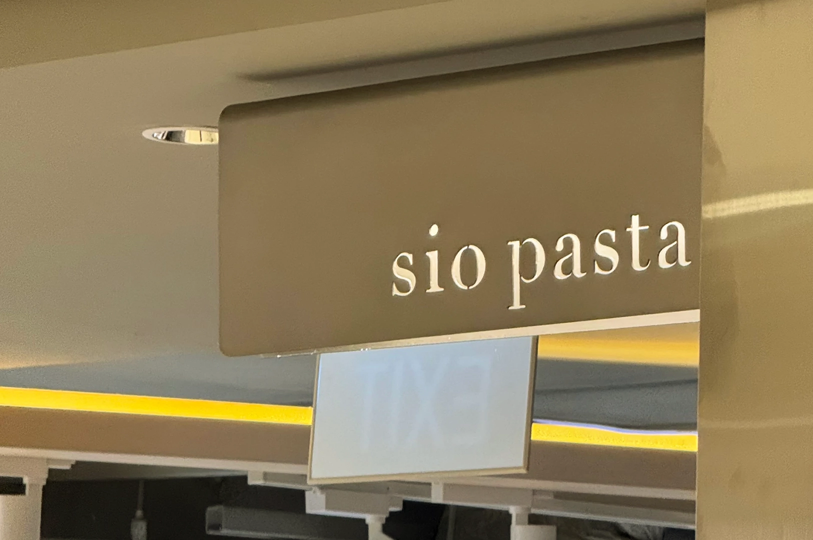 Low-angle close-up of the Sio Pasta restaurant sign at Raffles City Singapore, home to Japanese-style handmade pasta and umami-rich signature sauces.