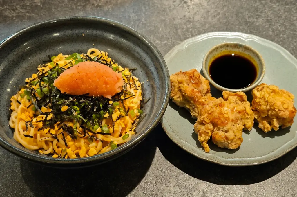 Overhead view of The Best Mentaiko Pasta and Japanese-style karaage at Sio Pasta Singapore, featuring handmade noodles, mentaiko roe, seaweed, spring onions, and crispy fried chicken.